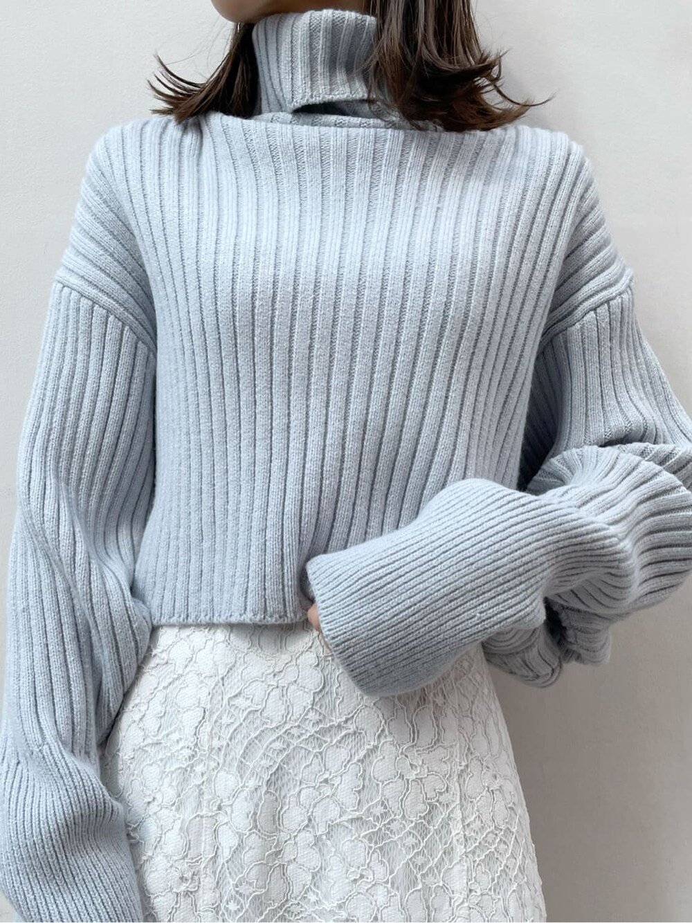 ホワイト系のスカート、ベージュ系のブーツ、ブルー系のニット/セーターを着用したレディースの秋コーディネートの7枚目の写真