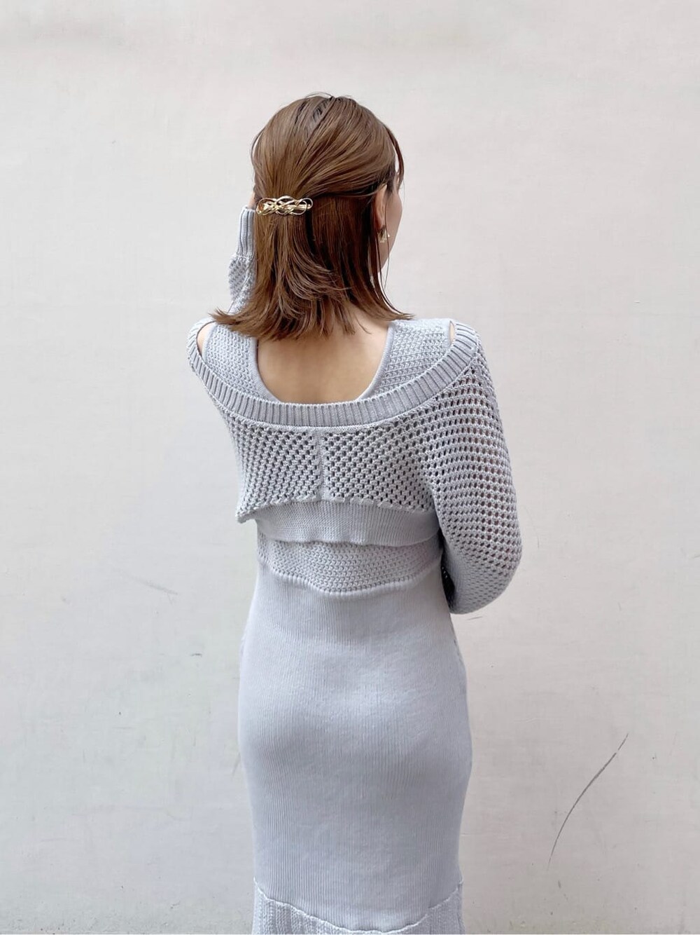 グレー系のワンピース、ホワイト系のハンドバッグ、ベージュ系のブーツを着用したレディースの秋コーディネートの7枚目の写真