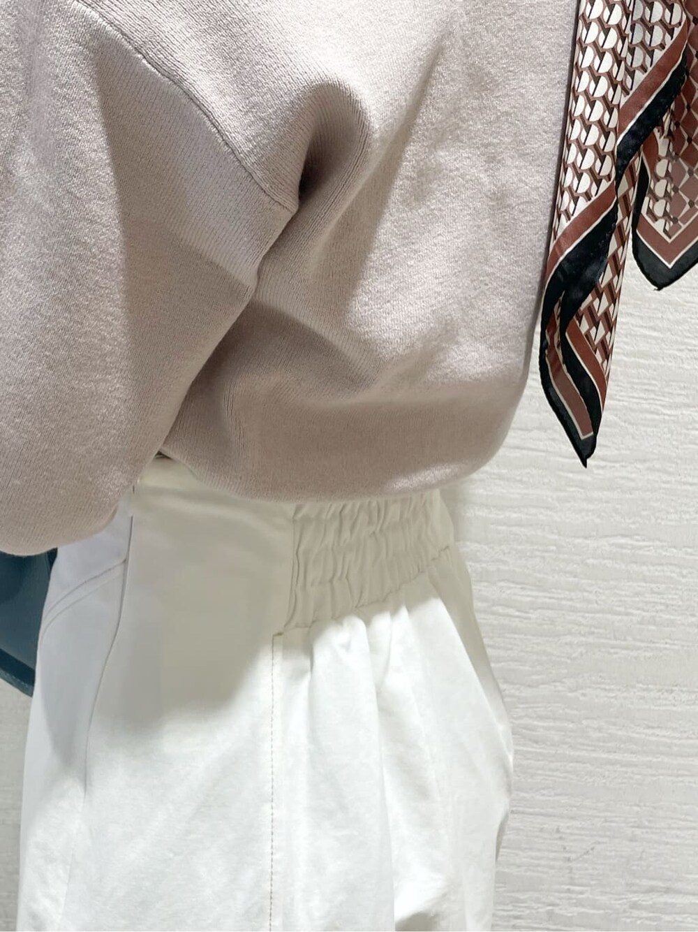 ベージュ系のニット/セーター、ブルー系のハンドバッグ、ベージュ系のブーツを着用したレディースの冬コーディネートの8枚目の写真