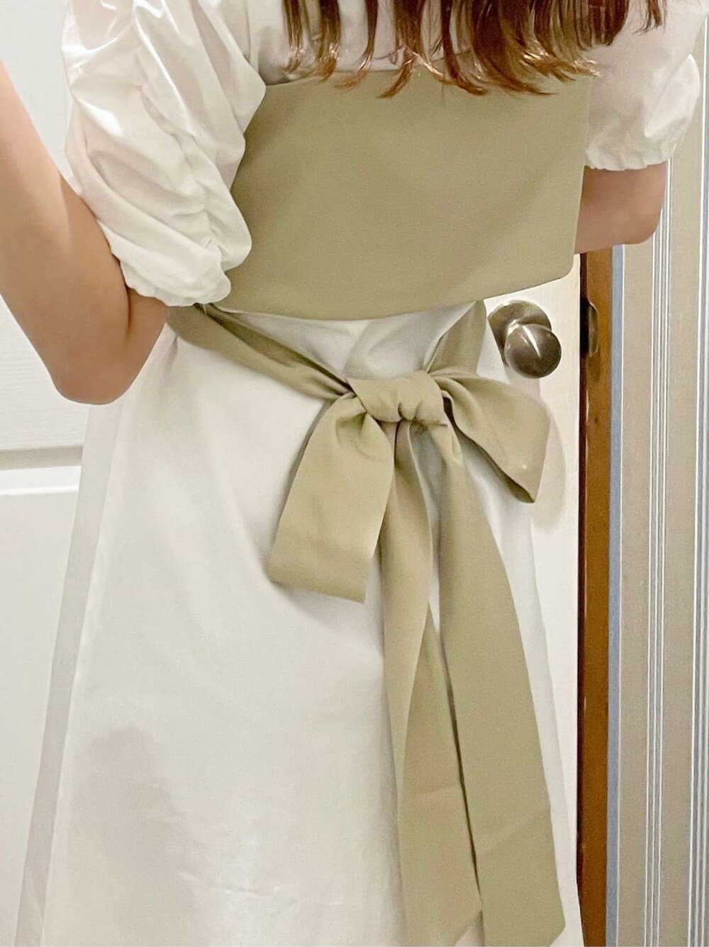 ブラック系のサンダル、ホワイト系のシャツワンピース、ブラウン系のイヤリングを着用したレディースの夏コーディネートの5枚目の写真