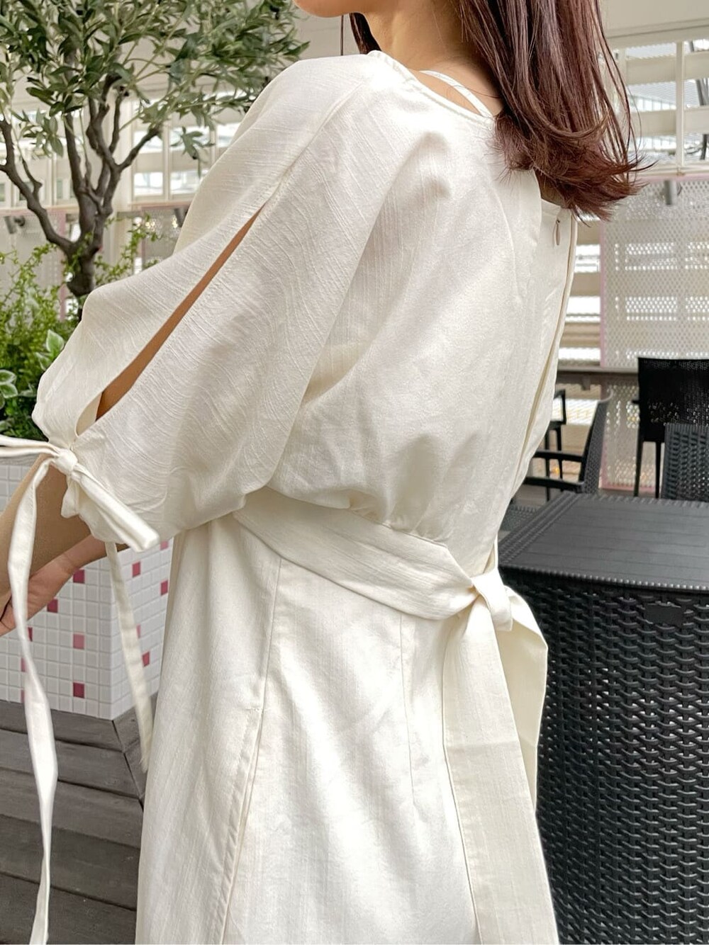 ベージュ系のデニムジャケット、ホワイト系のワンピース、ホワイト系のローファーを着用したレディースの春コーディネートの7枚目の写真