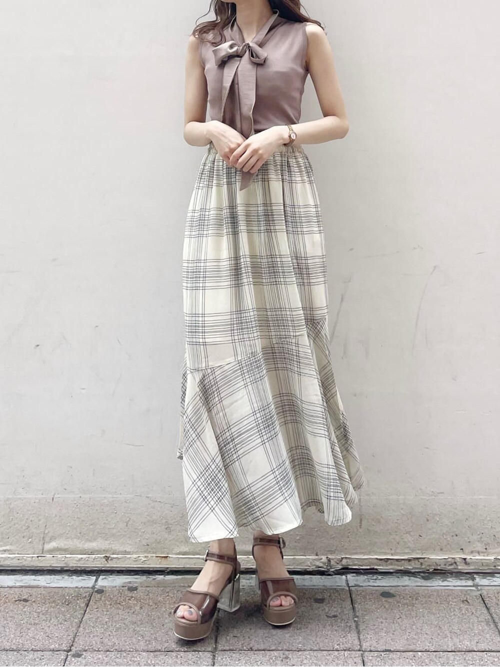 ブラウン系のサンダル、ベージュ系のニット/セーターを着用したレディースの夏コーディネートの2枚目の写真