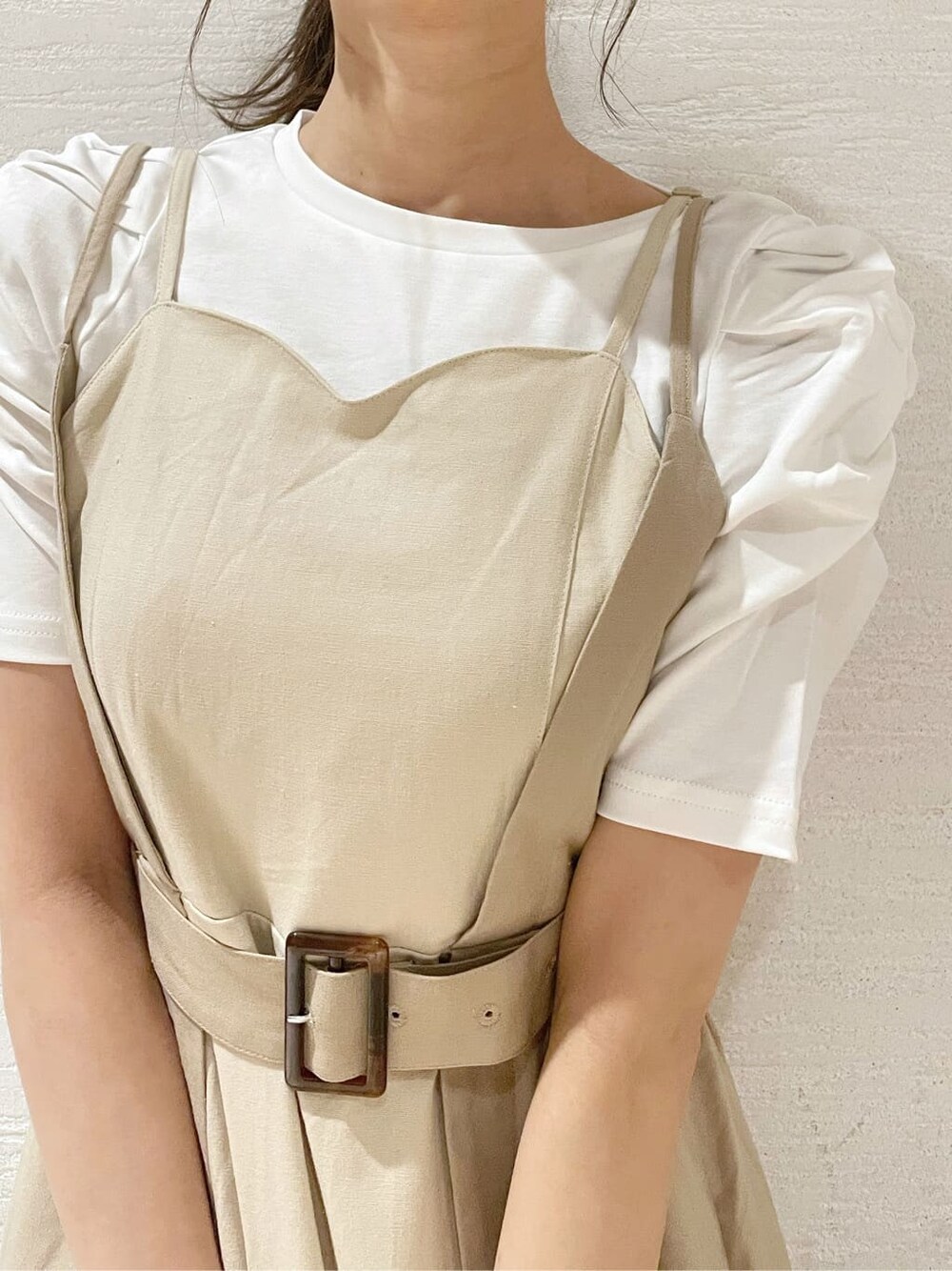 ホワイト系のスニーカー、ベージュ系のワンピース、ホワイト系のTシャツ/カットソーを着用したレディースの春コーディネートの6枚目の写真