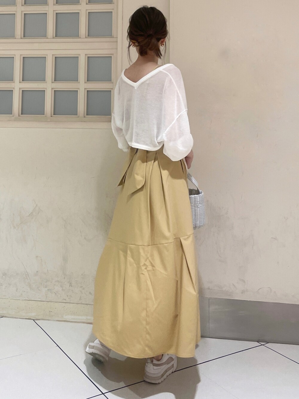 ホワイト系のカーディガン/ボレロ、イエロー系のワンピース、ホワイト系のハンドバッグを着用したレディースの夏コーディネートの4枚目の写真