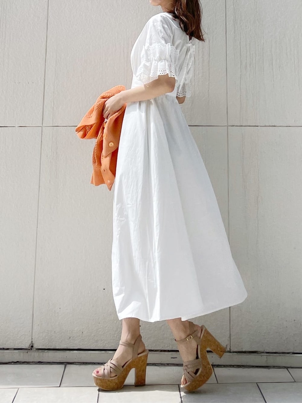 ホワイト系のワンピース、ベージュ系のサンダル、オレンジ系のカーディガン/ボレロを着用したレディースの春コーディネートの4枚目の写真