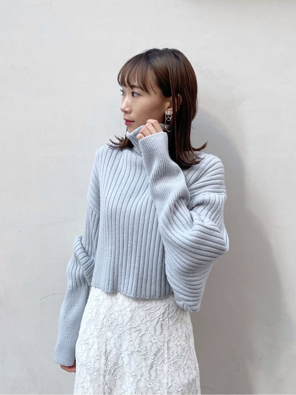 ホワイト系のスカート、ベージュ系のブーツ、ブルー系のニット/セーターを着用したレディースの秋コーディネートの4枚目の写真