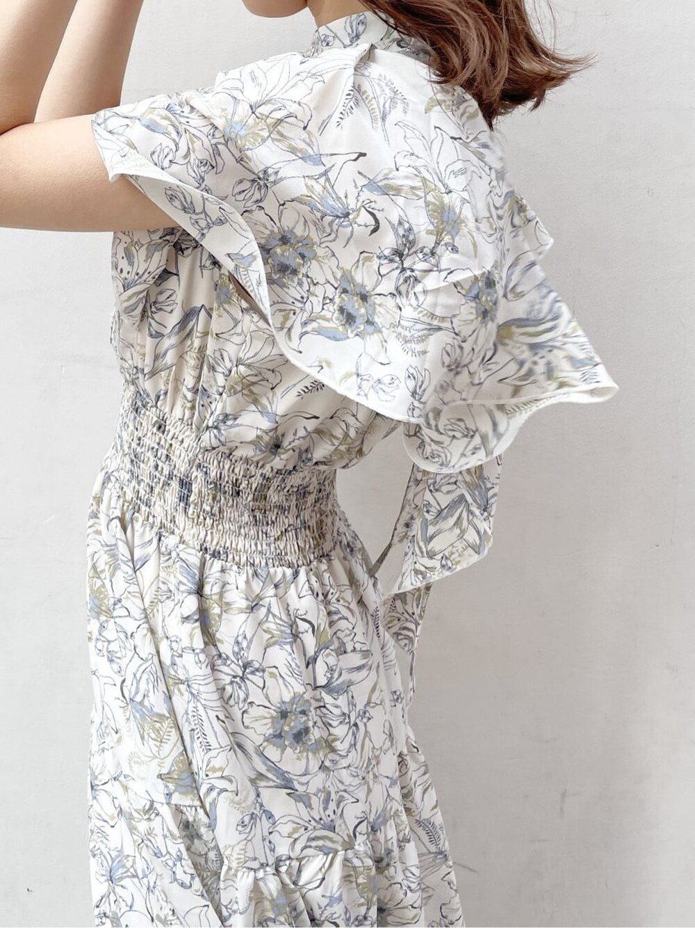 ベージュ系のトレンチコート、ホワイト系のワンピース、ベージュ系のブーツを着用したレディースの春コーディネートの9枚目の写真