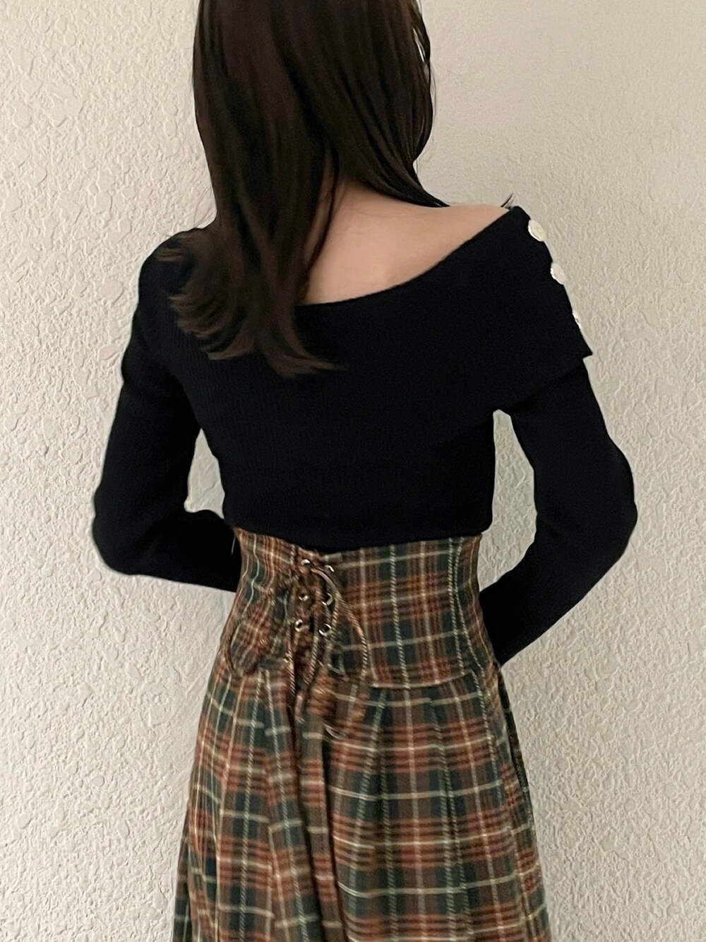 ブラック系のニット/セーター、ブラック系のブーツ、グリーン系のスカートを着用したレディースの秋コーディネートの7枚目の写真