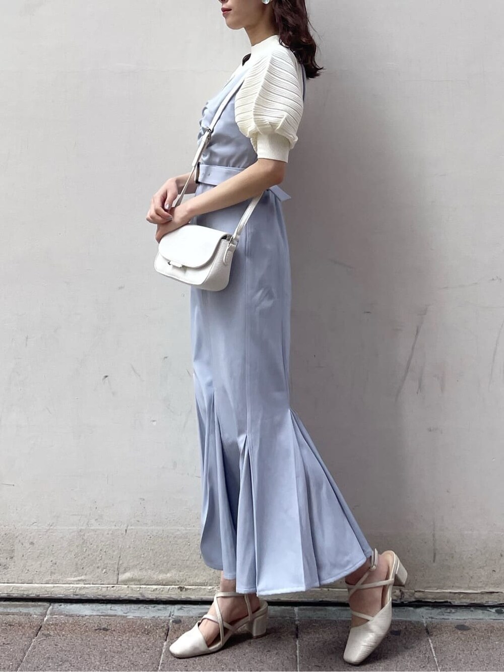 ブルー系のワンピース、ホワイト系のニット/セーター、ホワイト系のパンプスを着用したレディースの春コーディネートの2枚目の写真