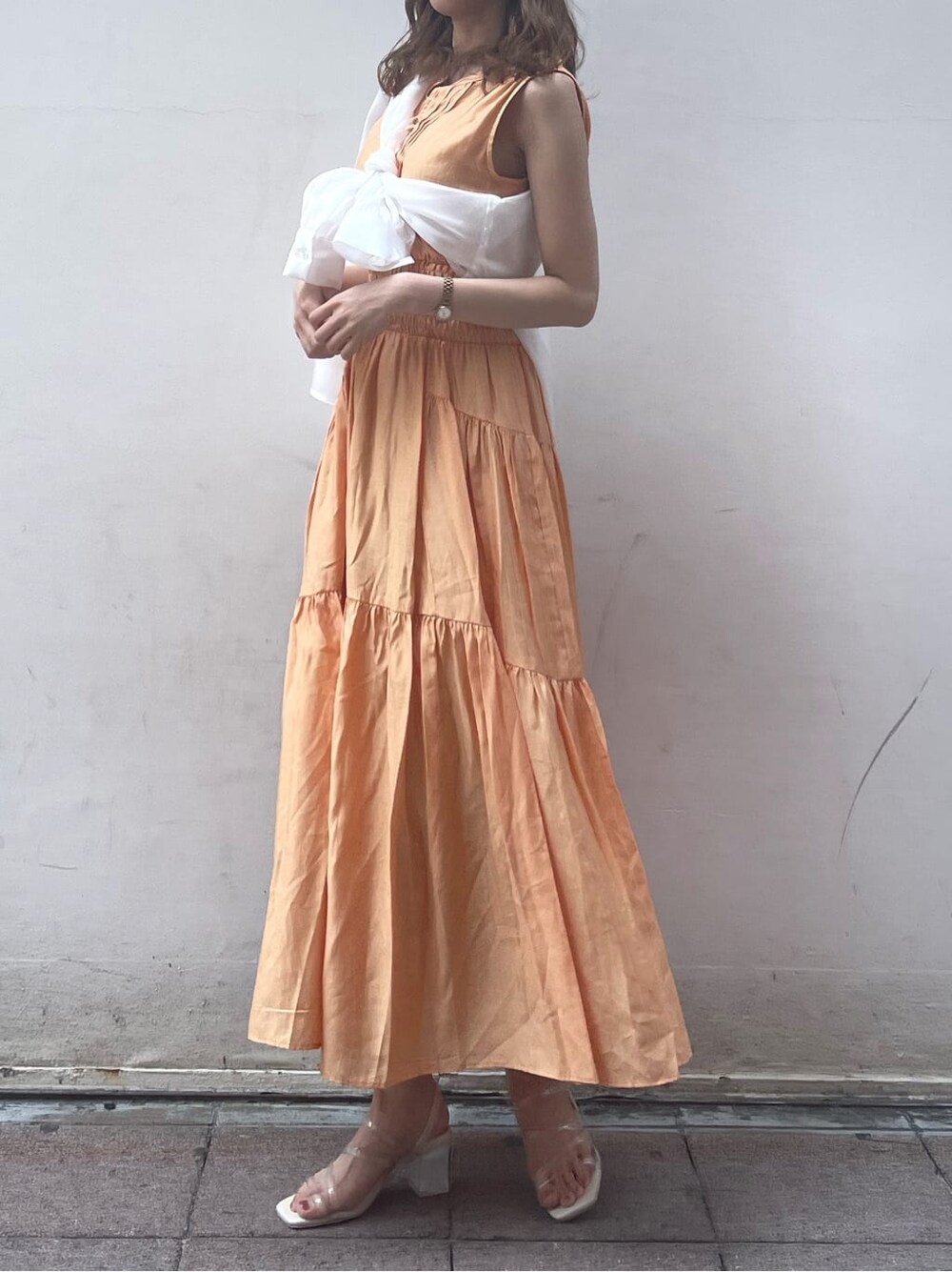 ホワイト系のシャツ/ブラウス、パープル系のサンダル、オレンジ系のワンピースを着用したレディースの春コーディネートの2枚目の写真