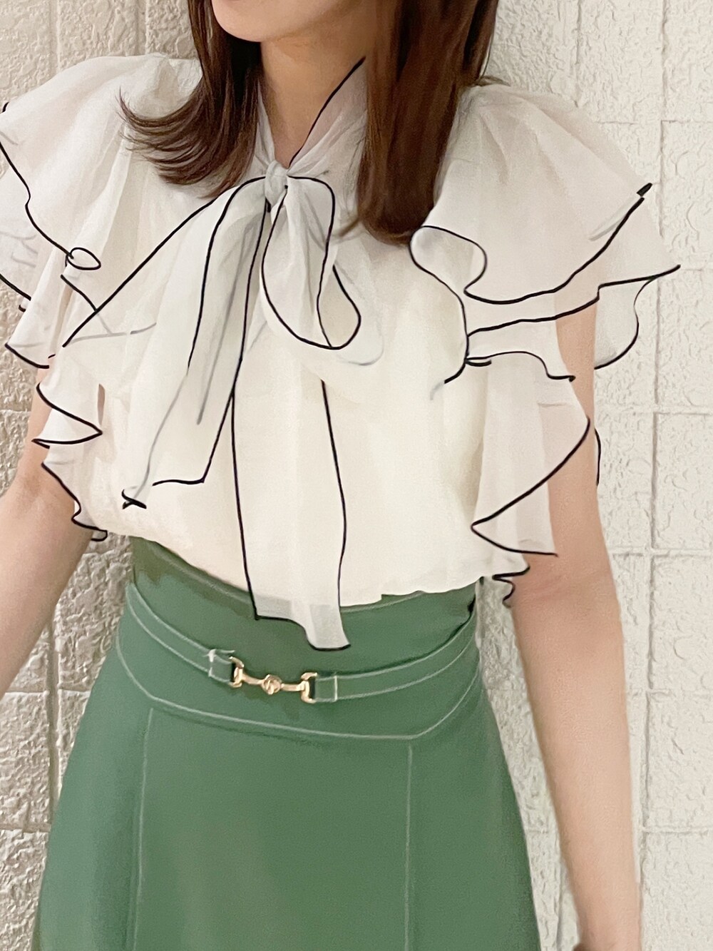 ホワイト系のシャツ/ブラウス、グリーン系のスカート、ホワイト系のパンプスを着用したレディースの春コーディネートの6枚目の写真