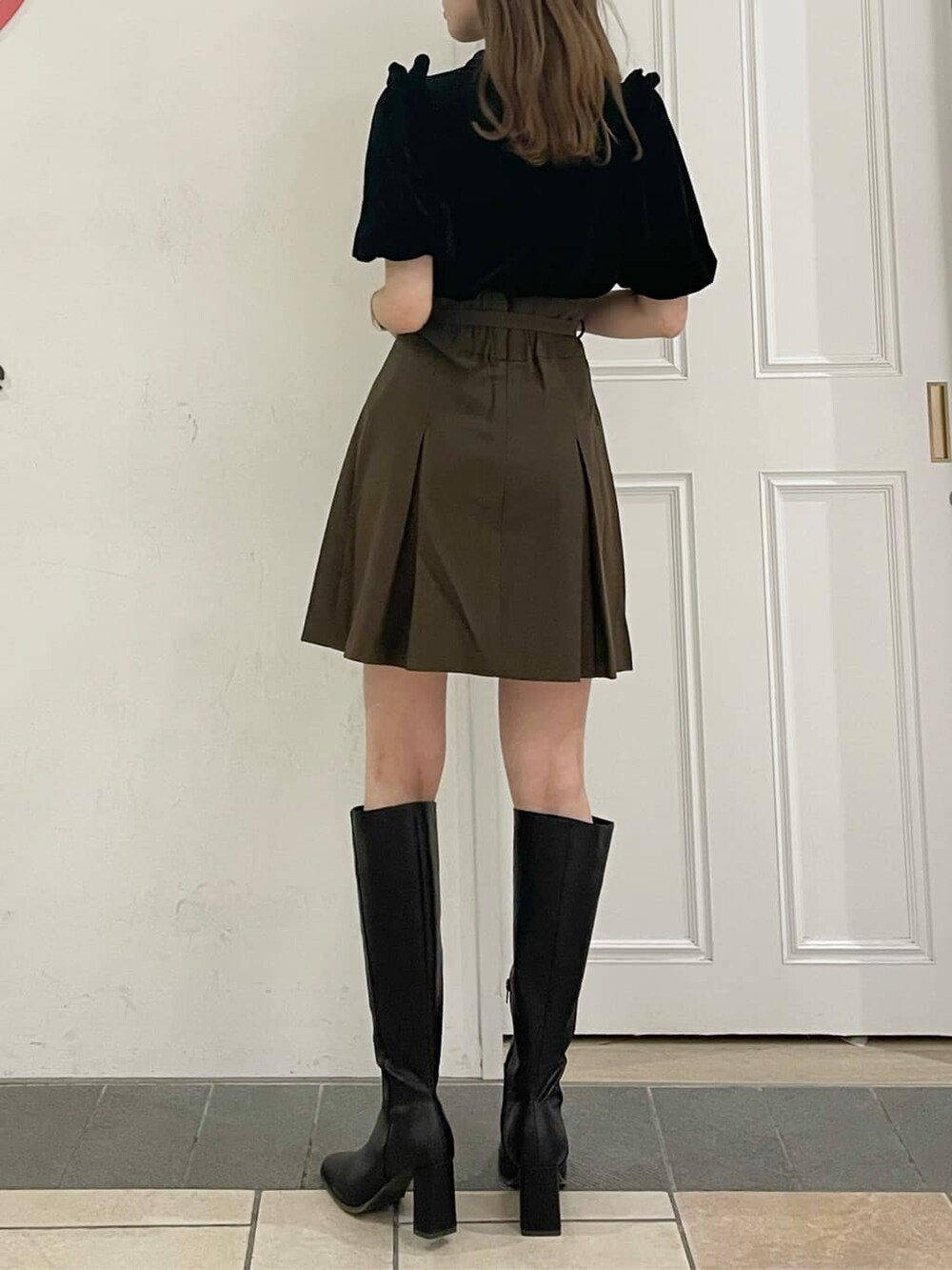 ブラウン系のスカート、ブラック系のブーツ、ブラック系のTシャツ/カットソーを着用したレディースの夏コーディネートの2枚目の写真