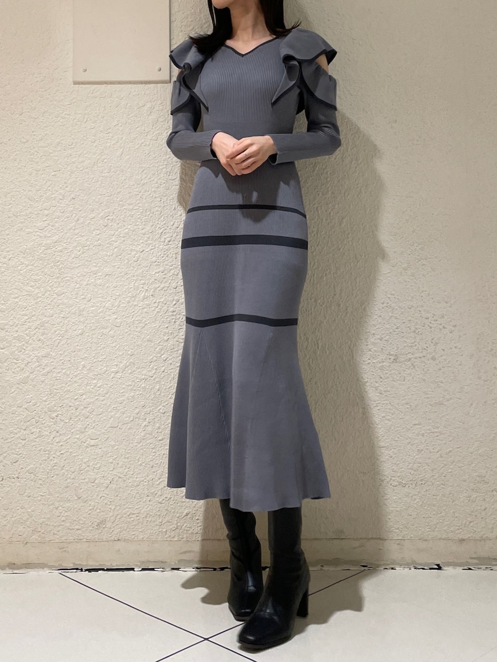 グレー系のワンピース、ブラック系のブーツを着用したレディースの冬コーディネートの3枚目の写真