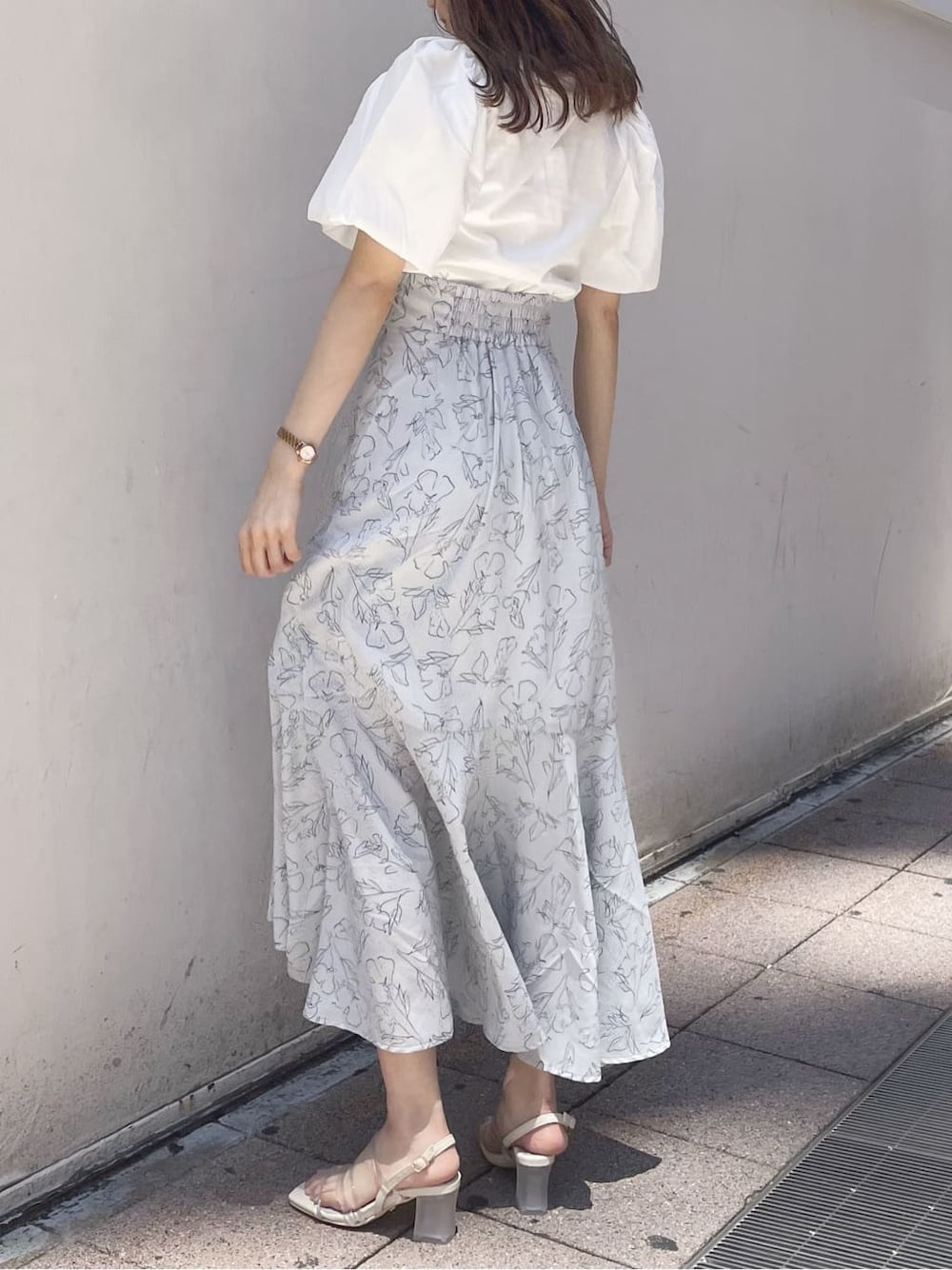 パープル系のサンダル、グレー系のスカート、ホワイト系のTシャツ/カットソーを着用したレディースの夏コーディネートの2枚目の写真