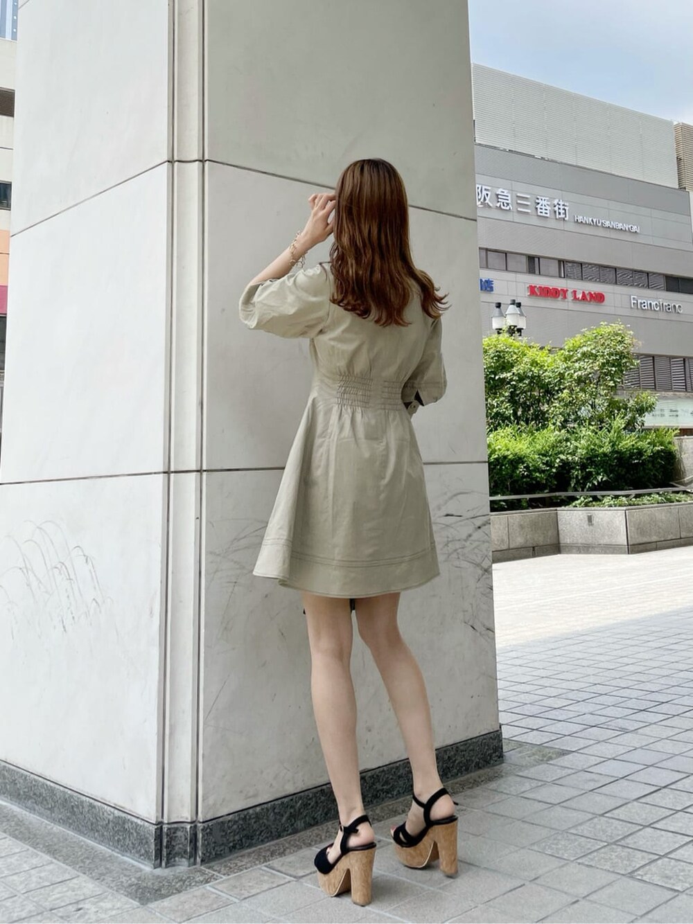 ブラック系のサンダル、ブラック系のハンドバッグ、ベージュ系のワンピースを着用したレディースの夏コーディネートの4枚目の写真