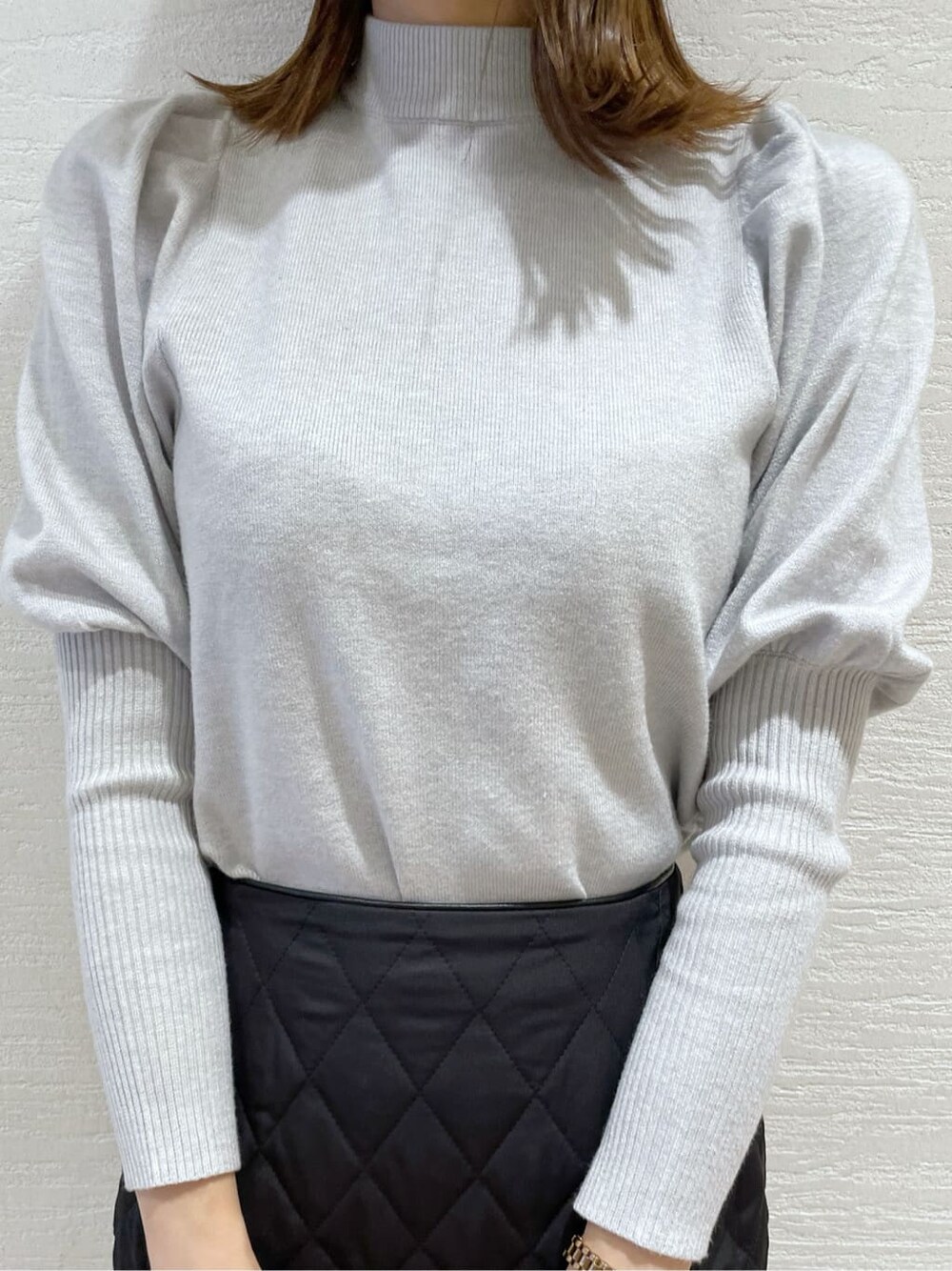 ブラック系のスカート、ブラック系のショルダーバッグ、グレー系のニット/セーターを着用したレディースの秋コーディネートの7枚目の写真