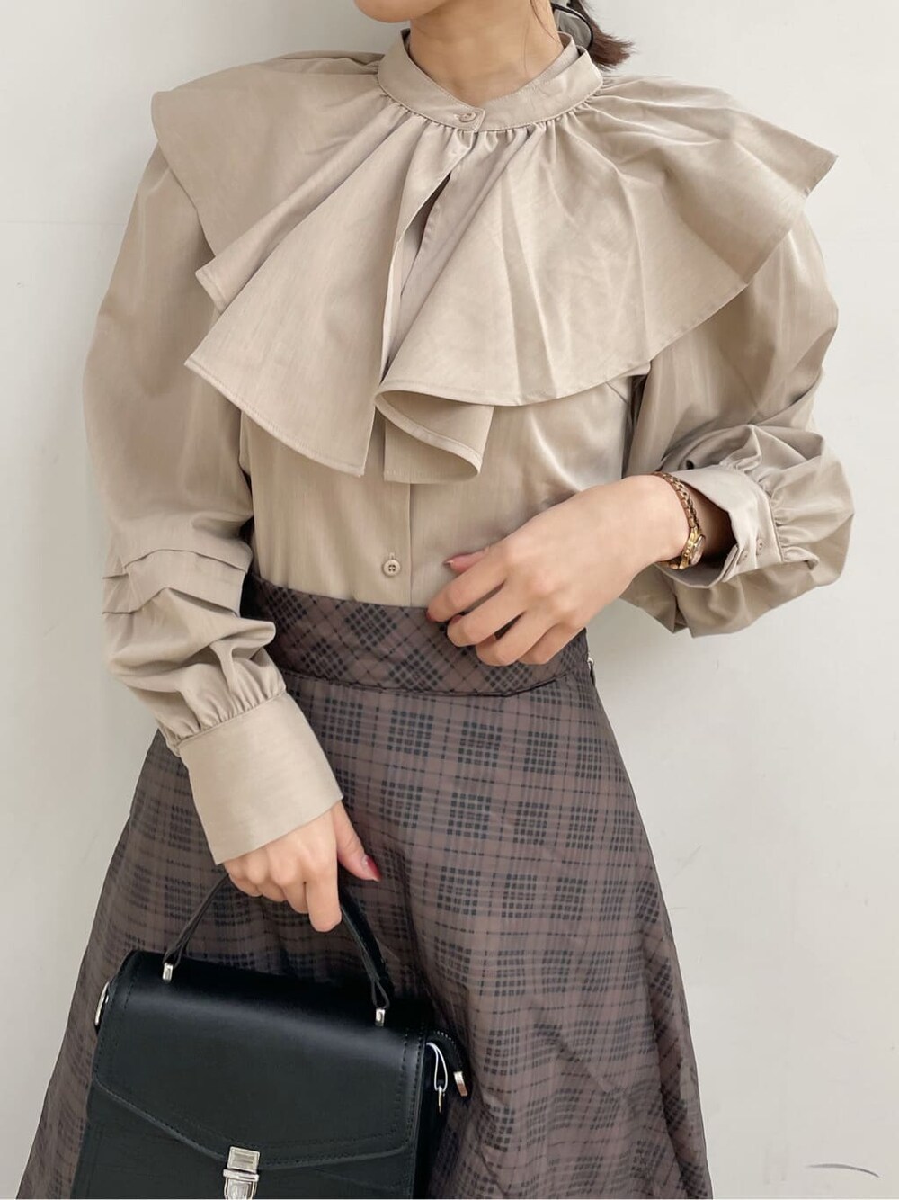 ブラック系のブーツ、ブラウン系のスカート、ベージュ系のシャツ/ブラウスを着用したレディースの冬コーディネートの4枚目の写真