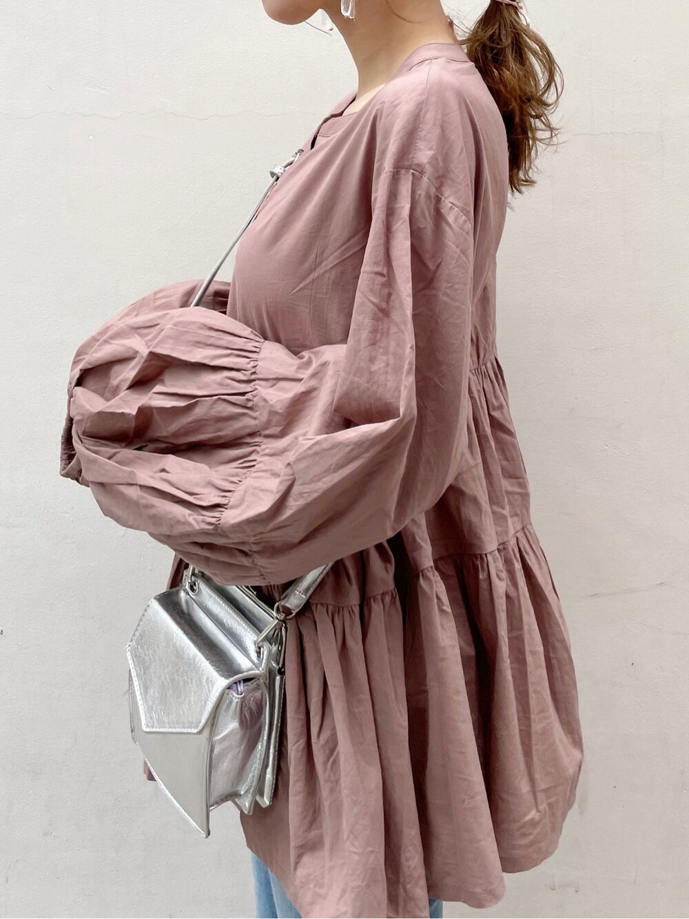 シルバー系のショルダーバッグ、ブルー系のデニムパンツ、ブラウン系のシャツ/ブラウスを着用したレディースの春コーディネートの6枚目の写真