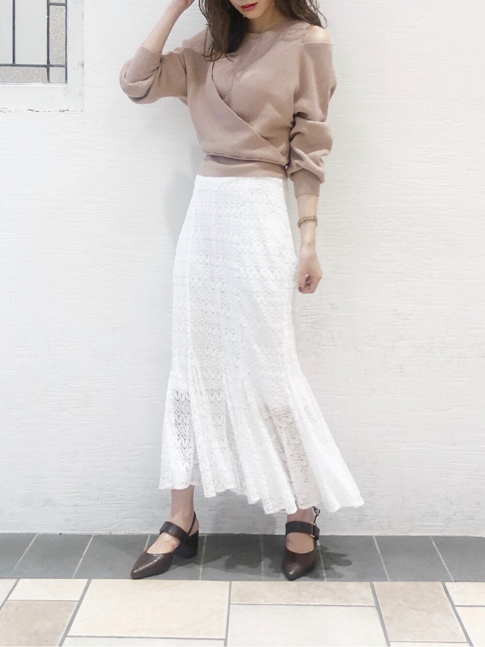 ブラウン系のパンプス、ベージュ系のニット/セーター、ホワイト系のスカートを着用したレディースの夏コーディネートの2枚目の写真