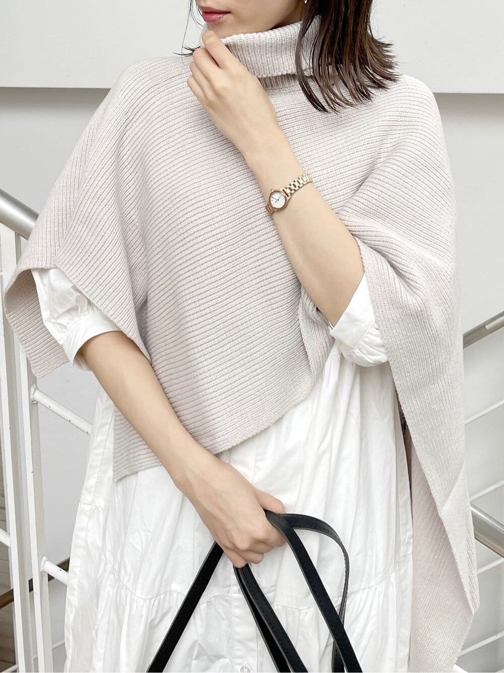 ホワイト系のワンピース、ブラック系のショルダーバッグ、ベージュ系のニット/セーターを着用したレディースの秋コーディネートの5枚目の写真