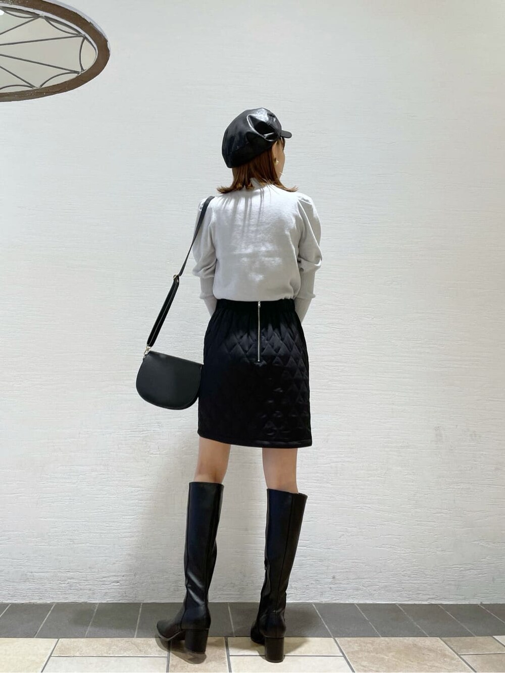 ブラック系のスカート、ブラック系のショルダーバッグ、グレー系のニット/セーターを着用したレディースの秋コーディネートの4枚目の写真