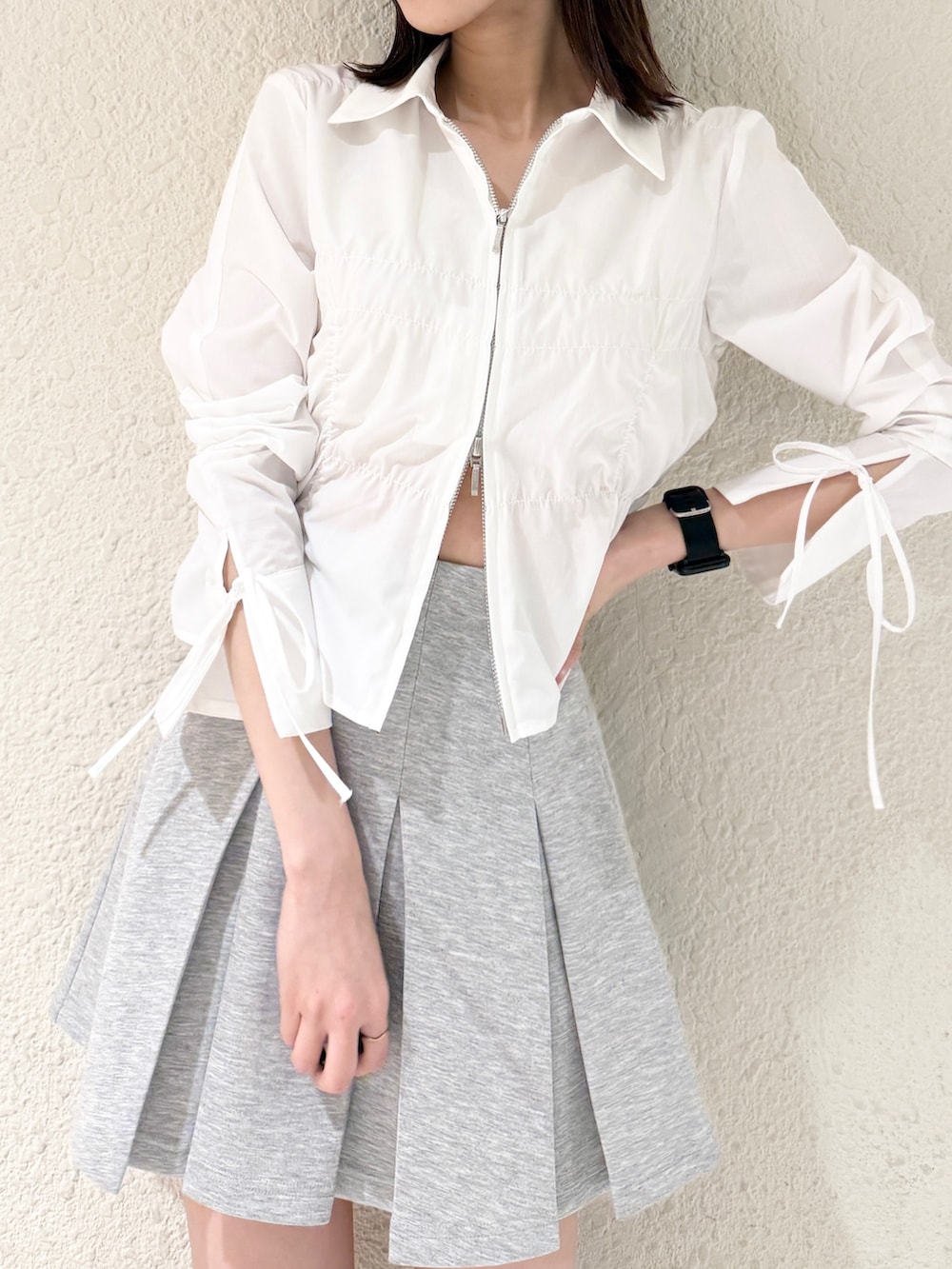 グレー系のスカート、ブラック系のハンドバッグ、ホワイト系のシャツ/ブラウスを着用したレディースの春コーディネートの4枚目の写真