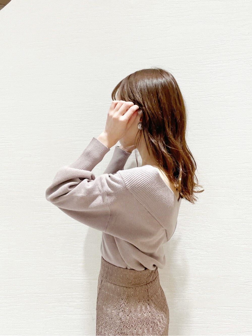 ホワイト系のブーツ、ベージュ系のスカート、パープル系のニット/セーターを着用したレディースの冬コーディネートの4枚目の写真