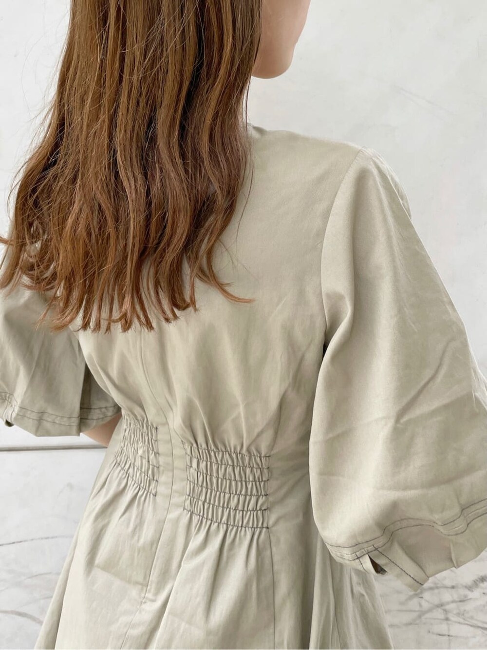 ブラック系のサンダル、ブラック系のハンドバッグ、ベージュ系のワンピースを着用したレディースの夏コーディネートの8枚目の写真