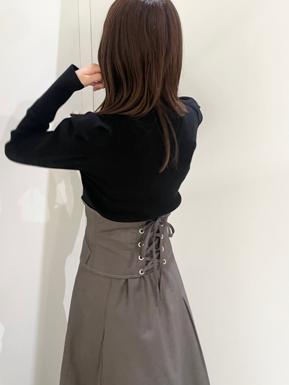 ブラック系のニット/セーター、ブラック系のローファー、グレー系のスカートを着用したレディースの秋コーディネートの6枚目の写真