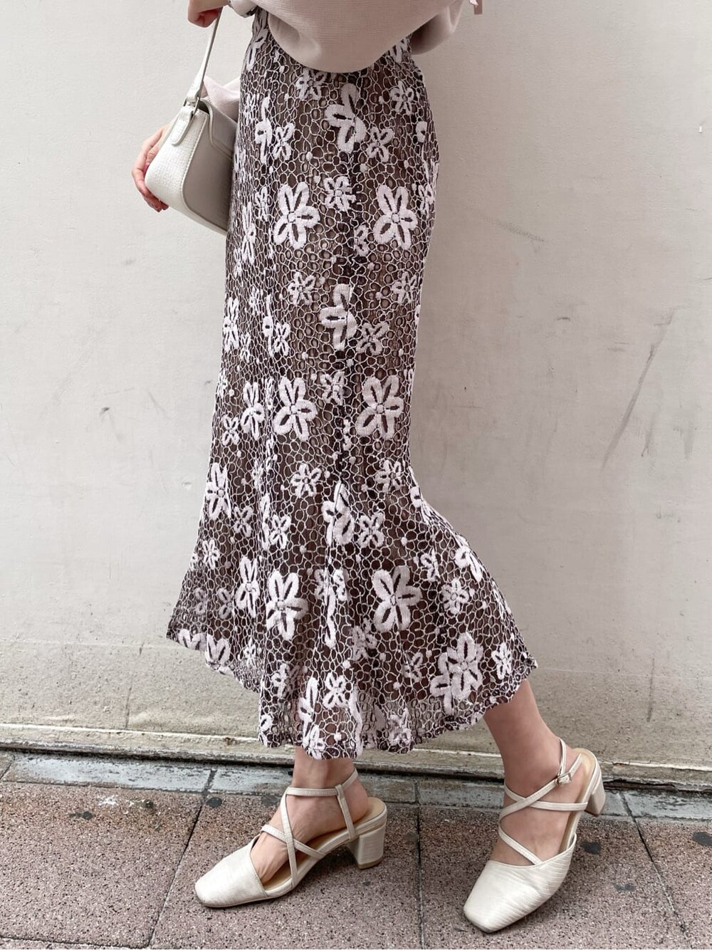 ブラウン系のスカート、ホワイト系のパンプス、ホワイト系のショルダーバッグを着用したレディースの春コーディネートの9枚目の写真