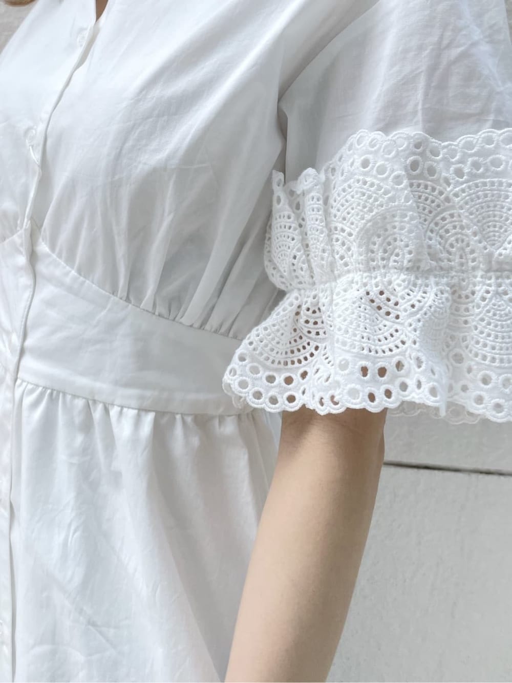 ホワイト系のワンピース、ベージュ系のサンダル、オレンジ系のカーディガン/ボレロを着用したレディースの春コーディネートの9枚目の写真