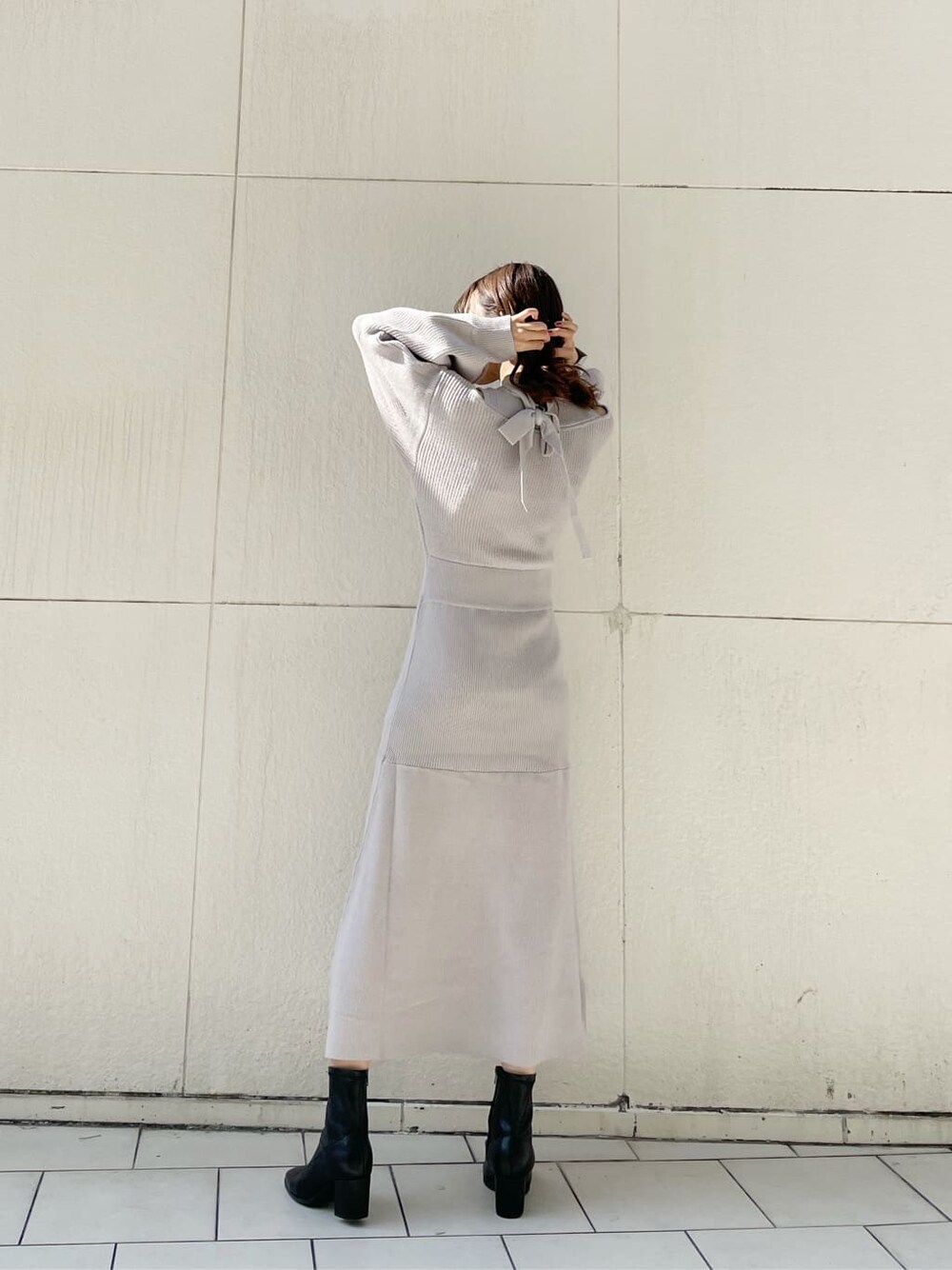 グレー系のブルゾン、ブラック系のブーツ、グレー系のワンピースを着用したレディースの秋コーディネートの7枚目の写真