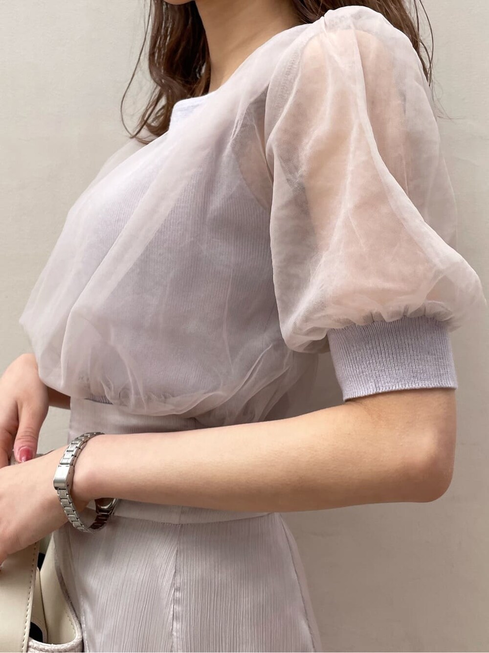 パープル系のニット/セーター、グレー系のスカート、ホワイト系のパンプスを着用したレディースの春コーディネートの6枚目の写真