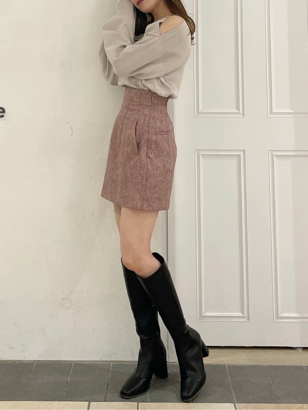 グレー系のニット/セーター、レッド系のスカート、ブラック系のブーツを着用したレディースの夏コーディネートの4枚目の写真