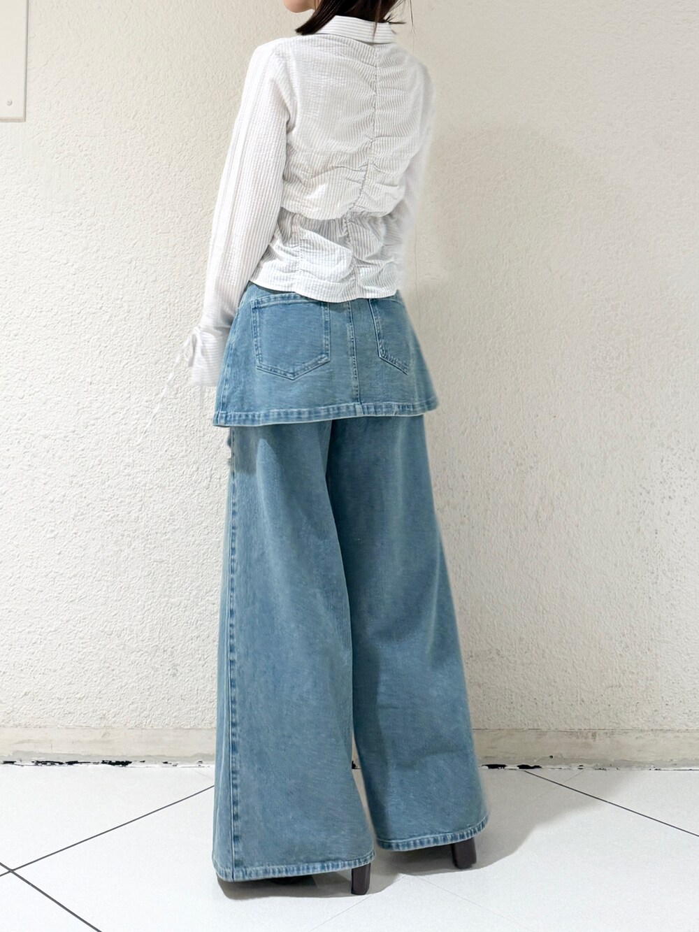 ブルー系のシャツ/ブラウス、ブラウン系のローファー、ブルー系のデニムパンツを着用したレディースの春コーディネートの3枚目の写真