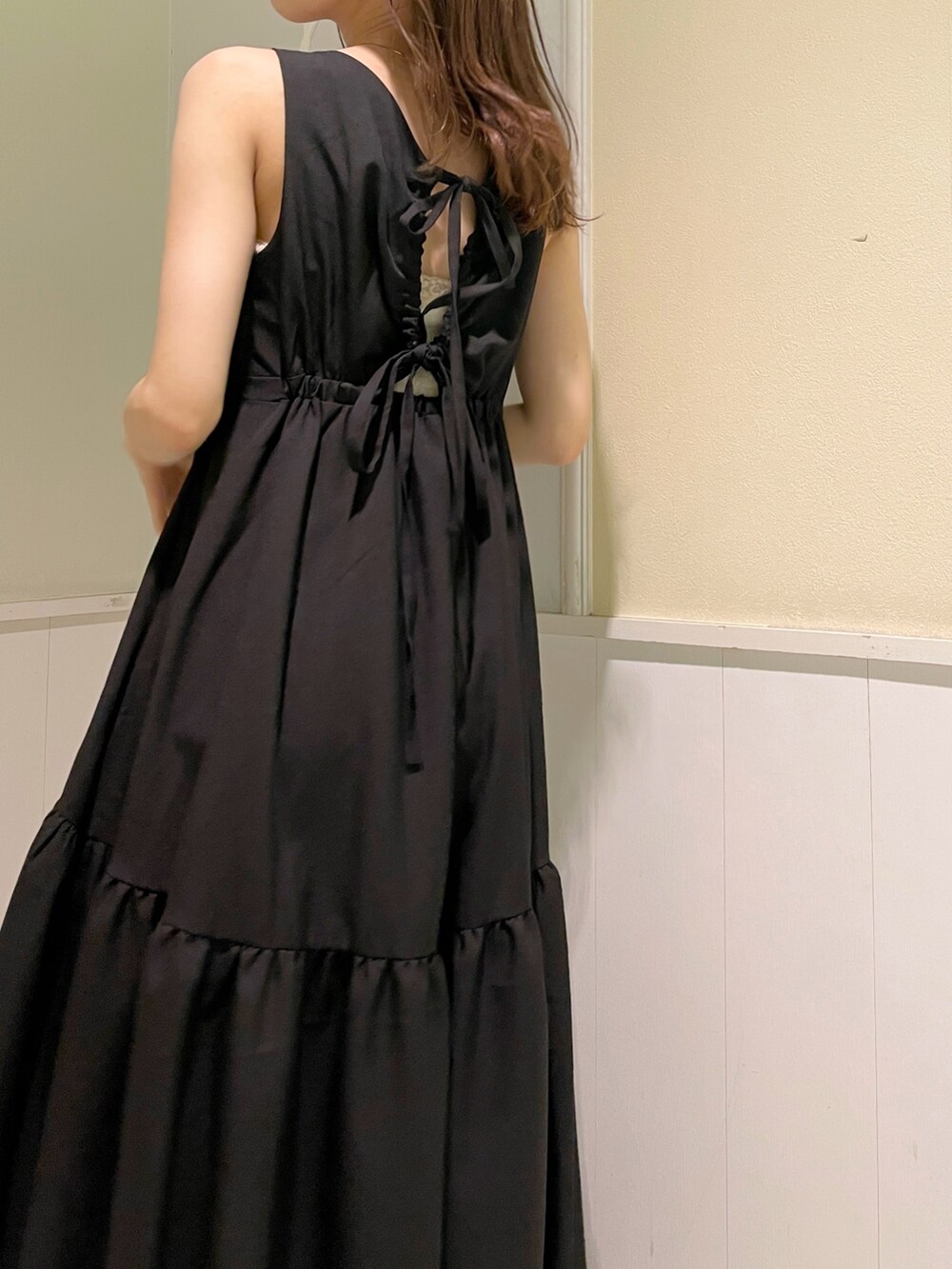 ブラック系のワンピース、ホワイト系のサンダル、ホワイト系のハンドバッグを着用したレディースの夏コーディネートの5枚目の写真