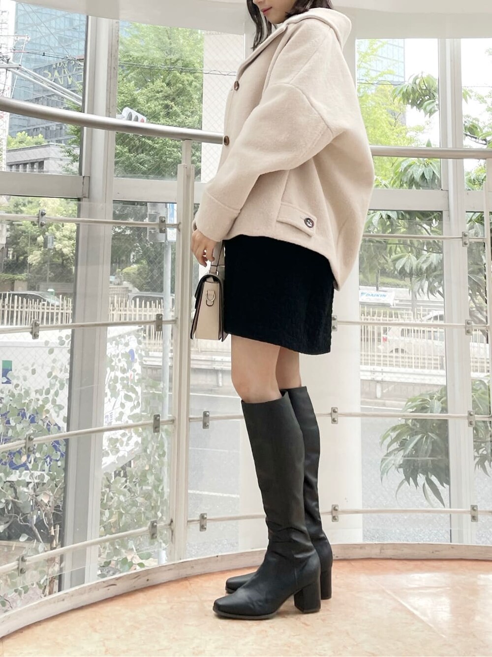 ブラック系のチュニック、ホワイト系のその他アウター、ブラック系のブーツを着用したレディースの夏コーディネートの2枚目の写真