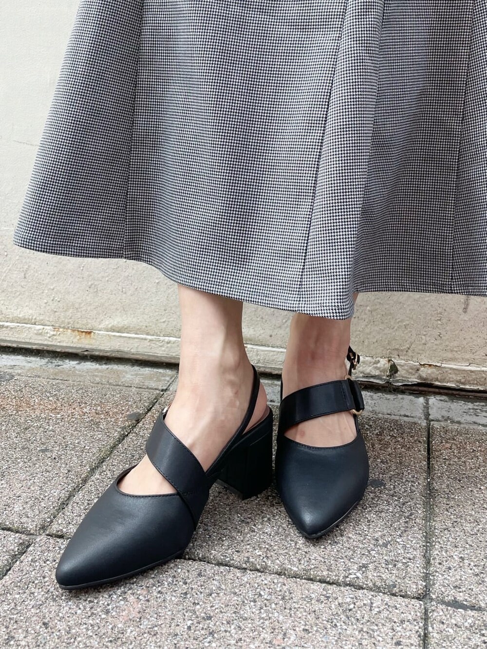 ブラック系のスカート、ブラック系のニット/セーター、ブラック系のハンドバッグを着用したレディースの秋コーディネートの10枚目の写真