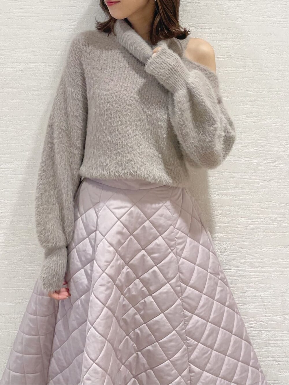 ピンク系のスカート、ブラック系のブーツ、ベージュ系のニット/セーターを着用したレディースの秋コーディネートの5枚目の写真