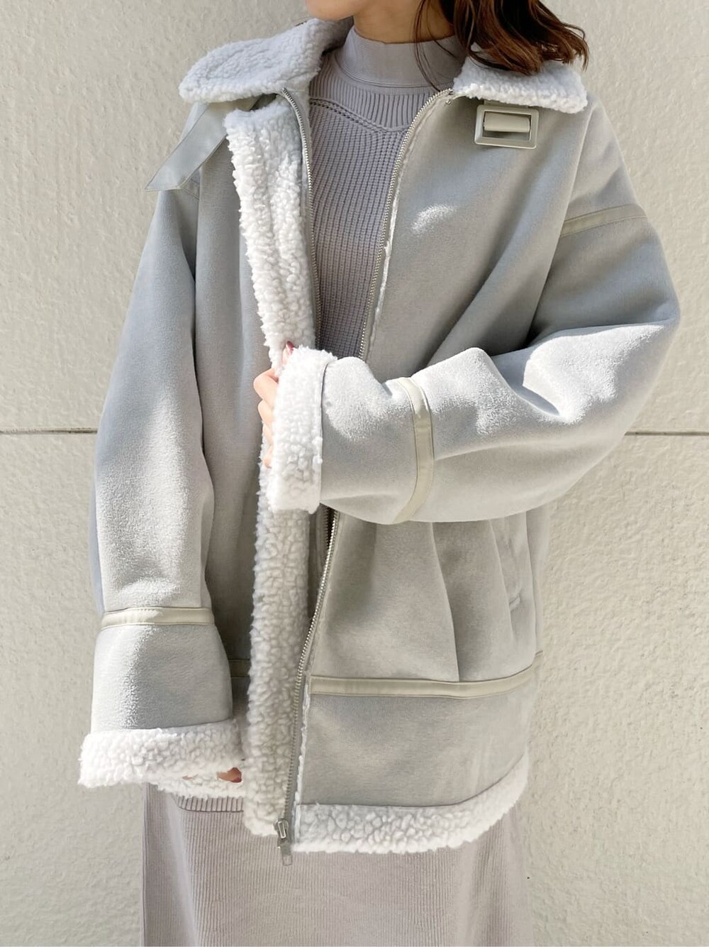 グレー系のブルゾン、ブラック系のブーツ、グレー系のワンピースを着用したレディースの秋コーディネートの3枚目の写真