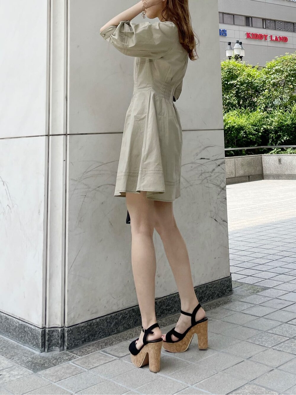 ブラック系のサンダル、ブラック系のハンドバッグ、ベージュ系のワンピースを着用したレディースの夏コーディネートの2枚目の写真