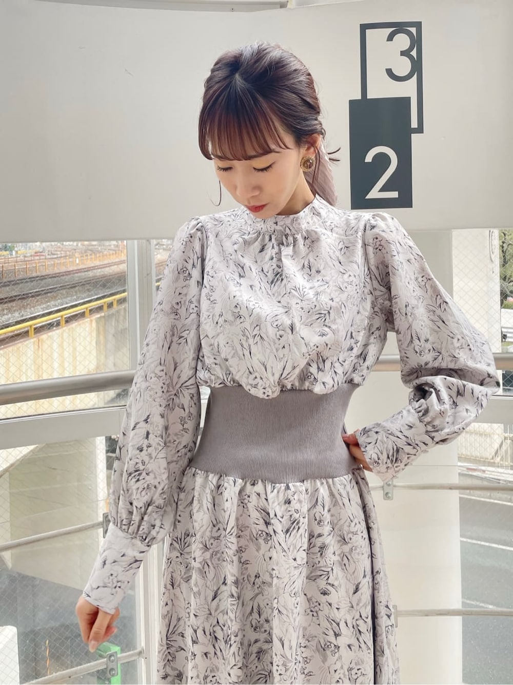 ブルー系のトレンチコート、グレー系のワンピース、ブラック系のローファーを着用したレディースの冬コーディネートの5枚目の写真