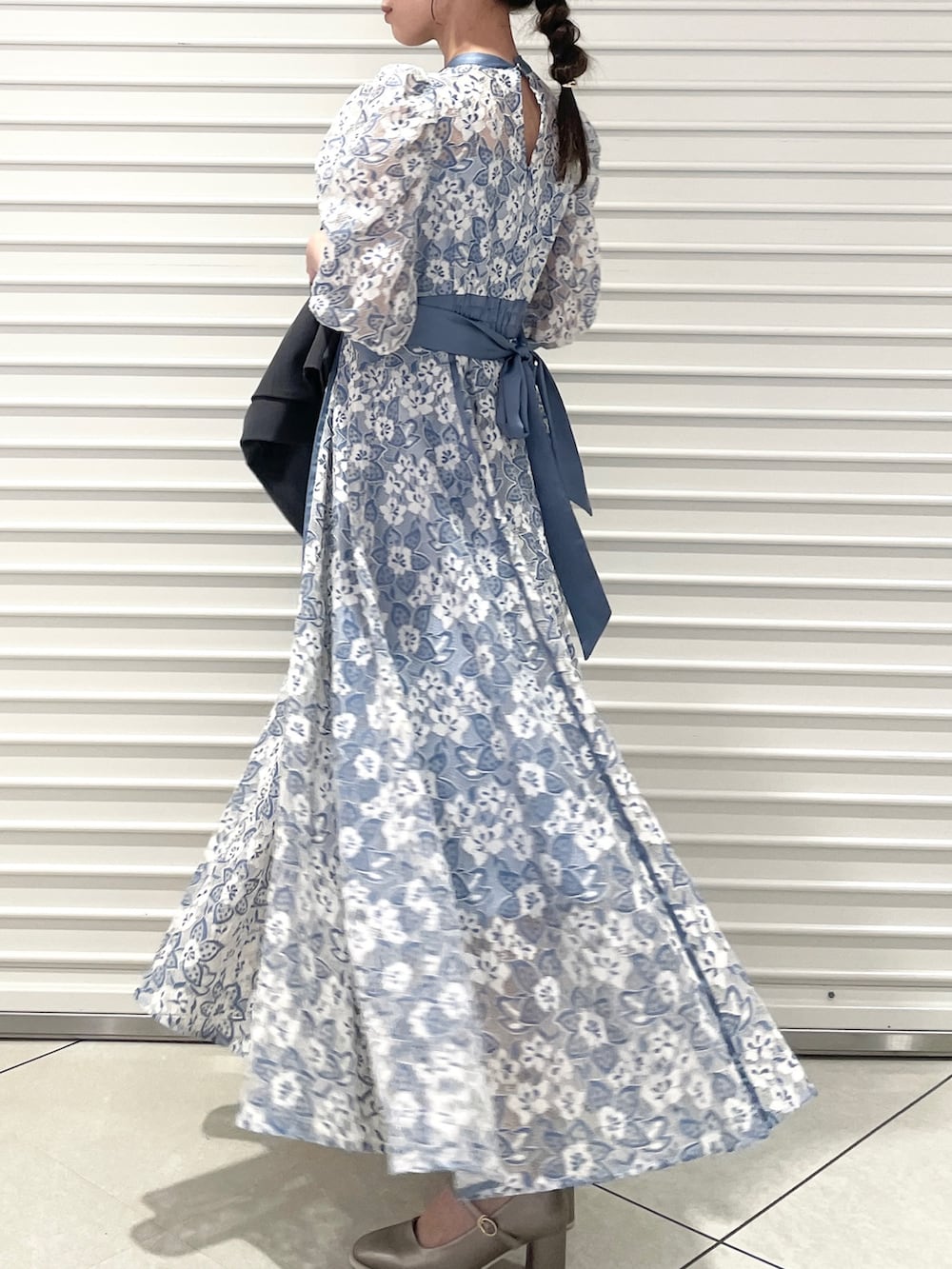 ブルー系のワンピース、シルバー系のパンプス、グレー系のテーラードジャケットを着用したレディースの冬コーディネートの6枚目の写真