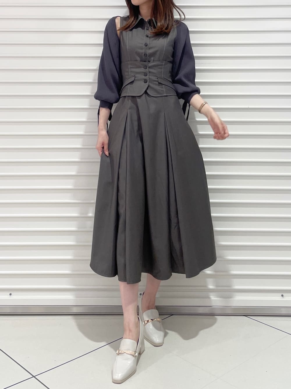 グレー系のワンピース、グレー系のカーディガン/ボレロ、ホワイト系のローファーを着用したレディースの夏コーディネートの2枚目の写真