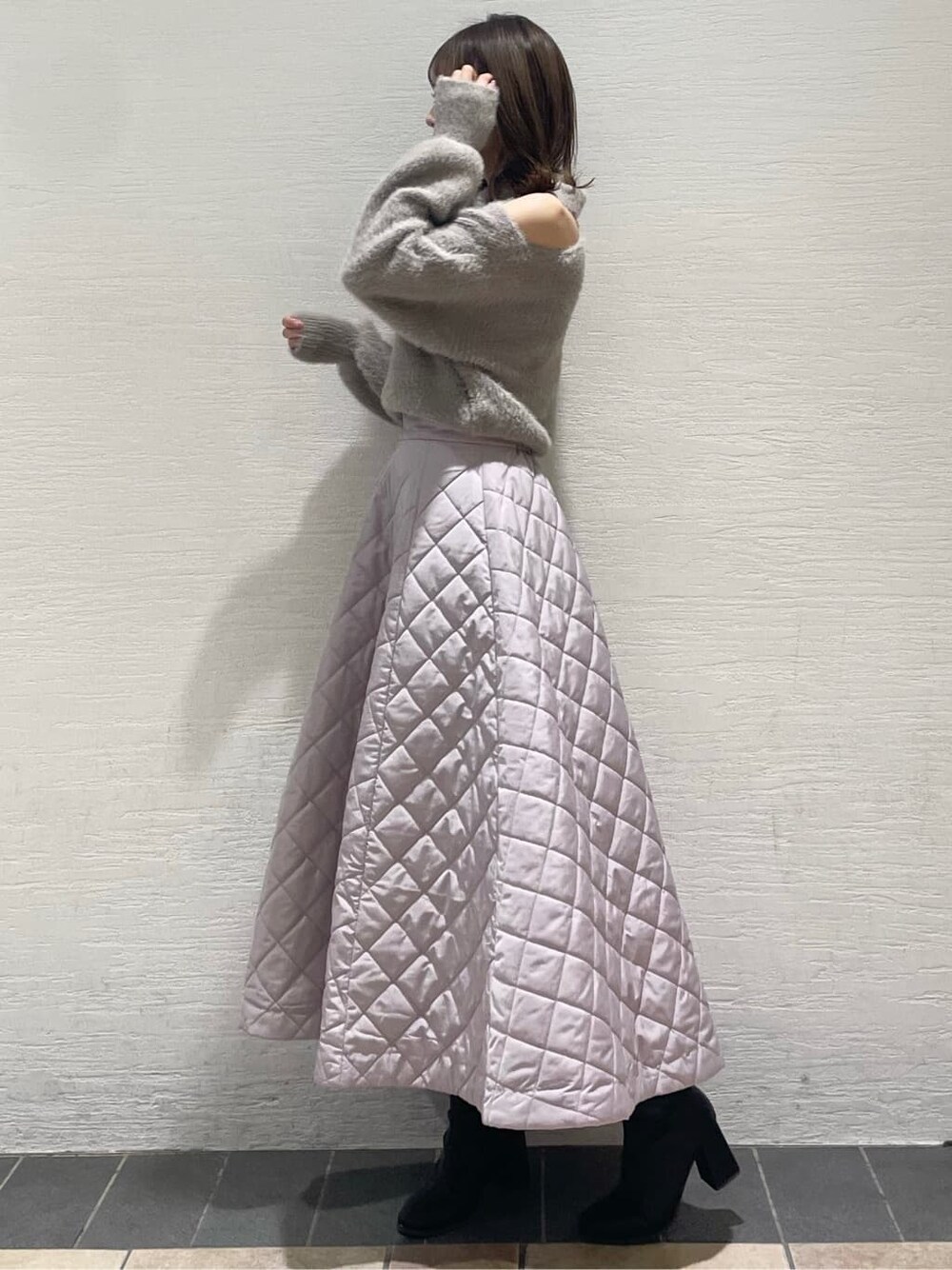 ピンク系のスカート、ブラック系のブーツ、ベージュ系のニット/セーターを着用したレディースの秋コーディネートの3枚目の写真