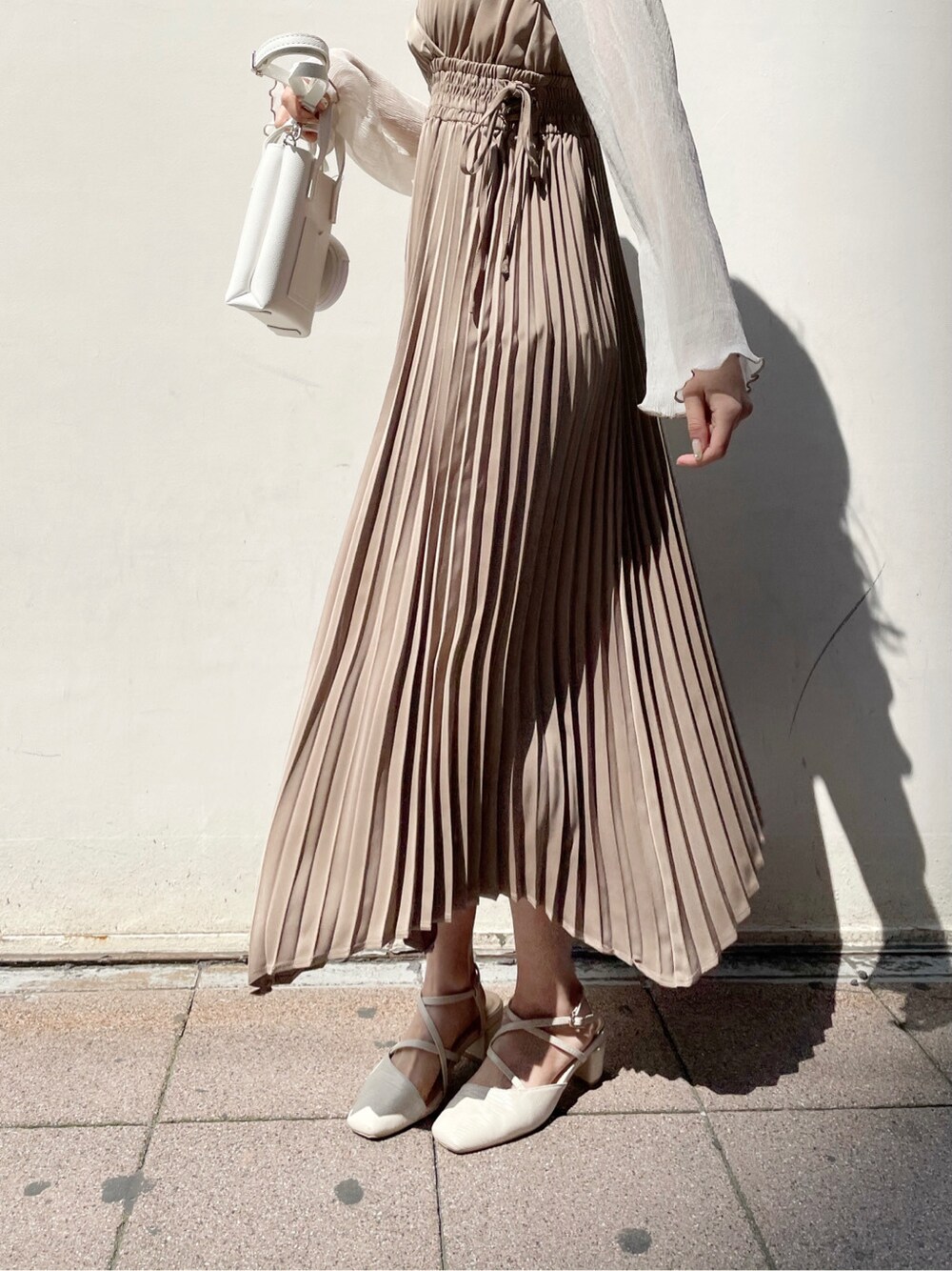 ベージュ系のワンピース、ベージュ系のTシャツ/カットソー、ホワイト系のパンプスを着用したレディースの春コーディネートの4枚目の写真