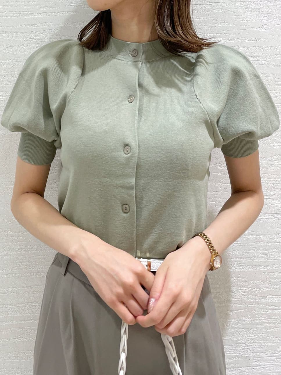 グレー系のその他パンツ、ホワイト系のハンドバッグ、グリーン系のニット/セーターを着用したレディースの夏コーディネートの4枚目の写真