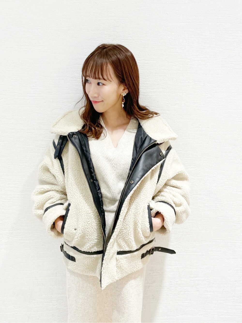 ベージュ系のワンピース、ブラウン系のブーツ、ブラウン系のハンドバッグを着用したレディースの冬コーディネートの2枚目の写真