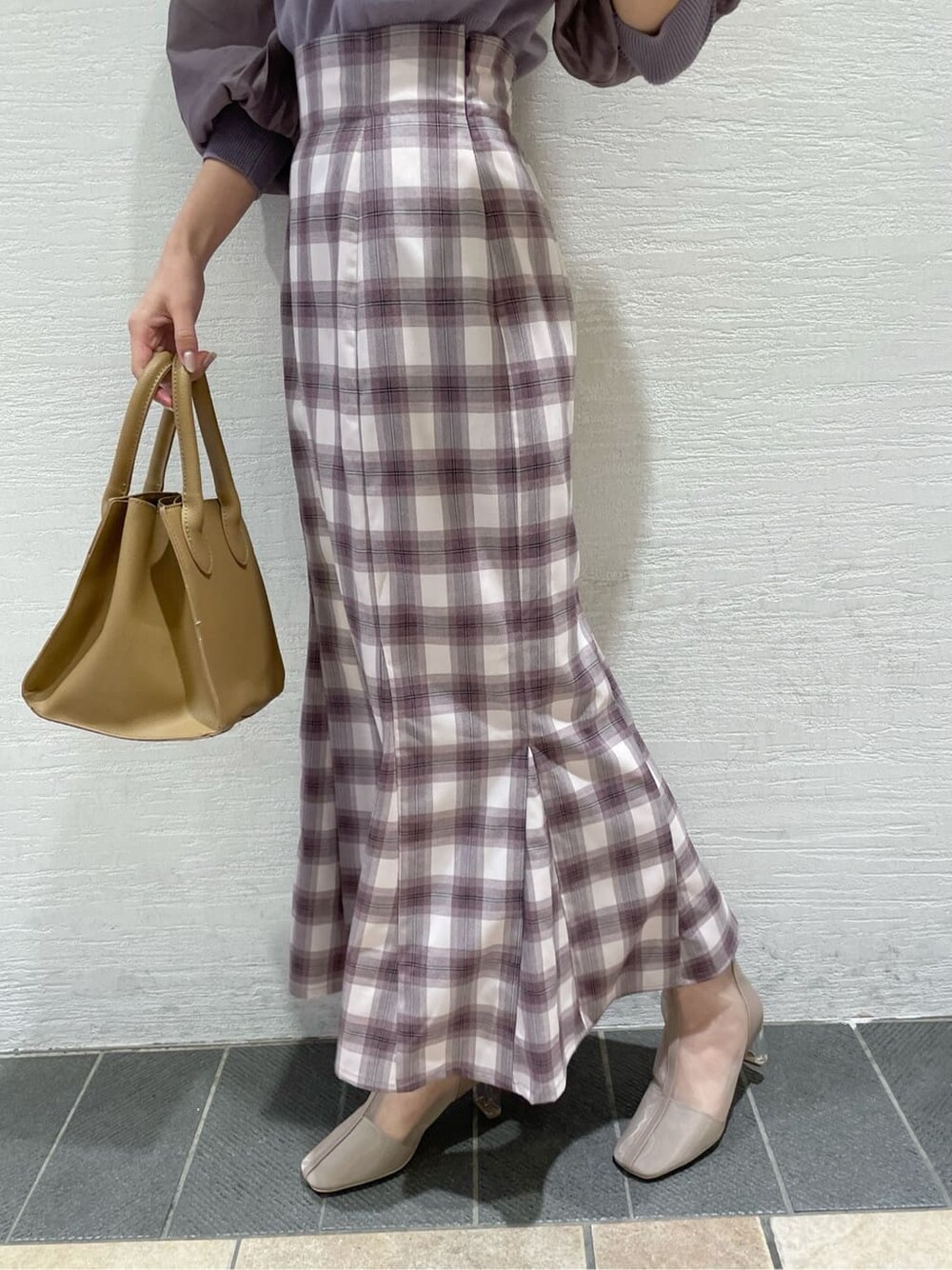 パープル系のスカート、ベージュ系のブーツ、パープル系のニット/セーターを着用したレディースの冬コーディネートの8枚目の写真