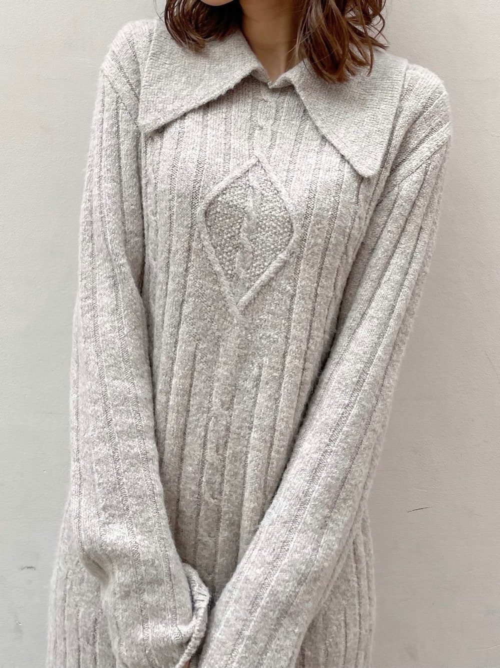 グレー系のワンピース、ホワイト系のハンドバッグ、ベージュ系のブーツを着用したレディースの秋コーディネートの5枚目の写真